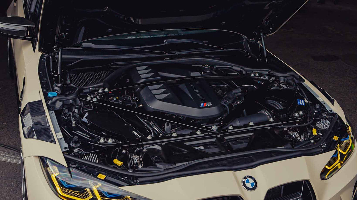 BMW M4 G82 mit geöffneter Motorhaube, S58 Motor im Motorraum sichtbar