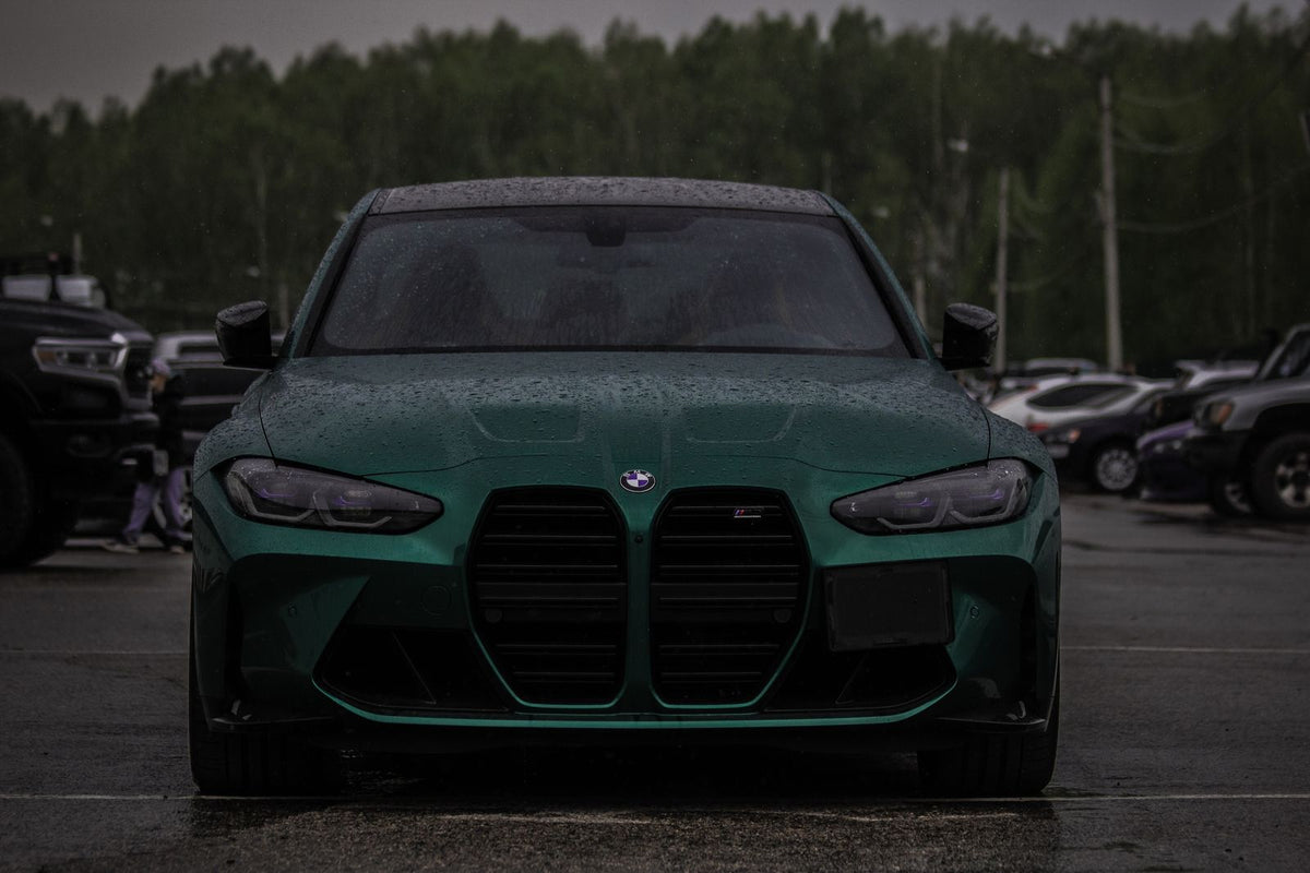 Grüner BMW frontal auf nassem Asphalt nach Regen – Auto winterfest machen